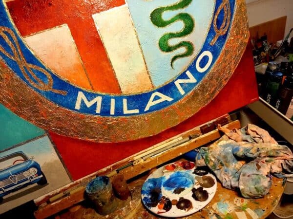 The Alfa Romeo logo as an handpainted canvas on an easel in the artist's studio